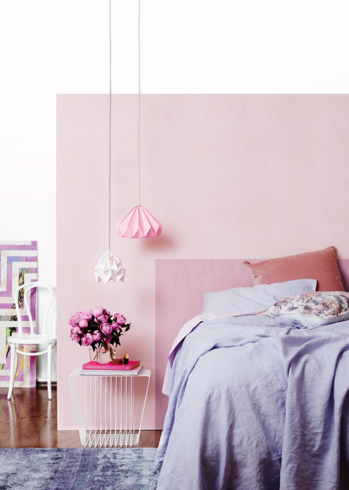 peinture murale de nuances rose et blanches, grand lit dans une chambre femme avec table basse et luminaires origami