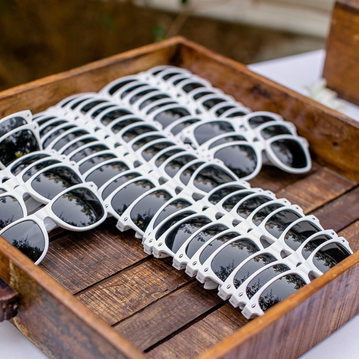 idée cadeau mariage pas cher, lunettes de soleil en blanc et noir à offrir aux invités d'un mariage sur la plage
