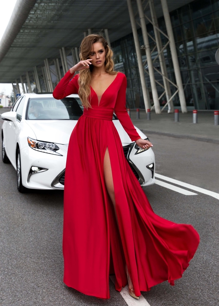 modèle de jolie robe rouge longue à design asymetrique avec décolleté en V et manches longues combinée avec sandales dorés