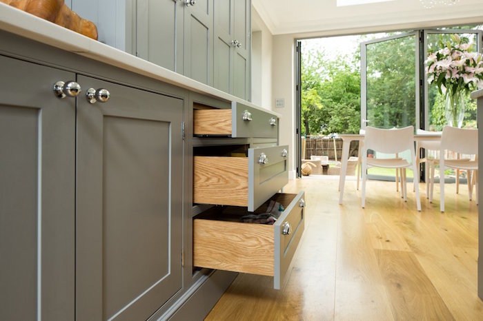 meuble gris de cuisine équipée ouverte avec sol en parquet flottant en bois