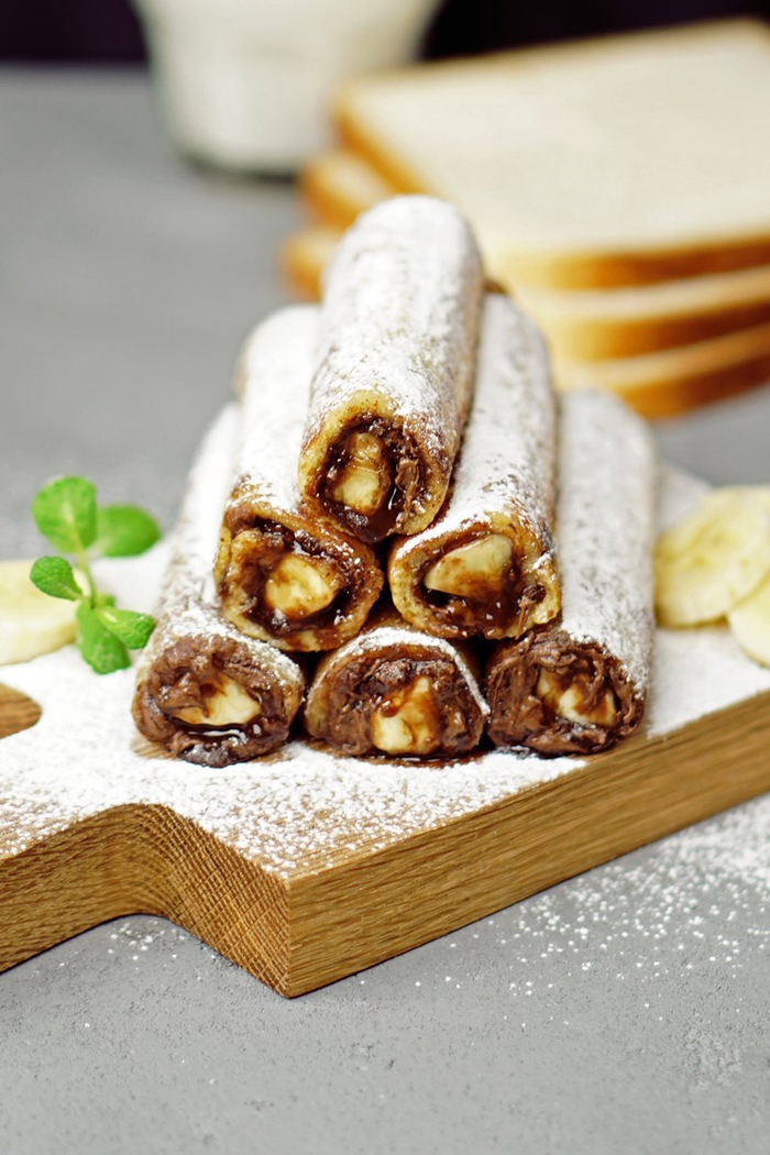 recette délicieuse de pain perdu roulé au nutella et à la banane saupoudré de sucre glace à partager entre amis