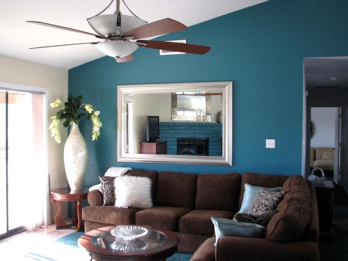 mur bleu pétrole de salon avec canapé retro en velours marron