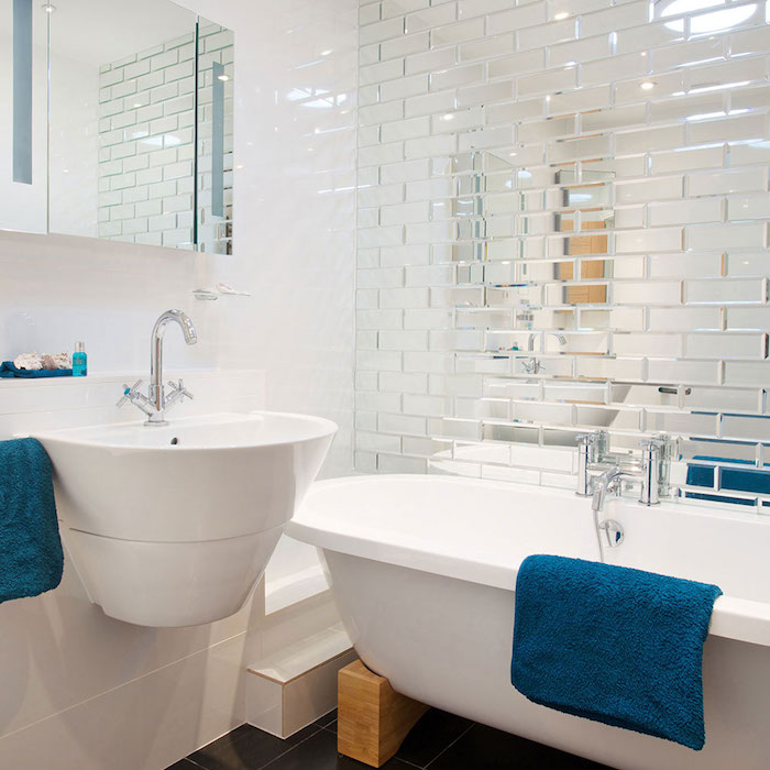 exemple petite salle de bain avec baignoire blanche sur pieds en bois lavabo blanc et serviettes de toilettes argent, sol carrelage gris anthracite