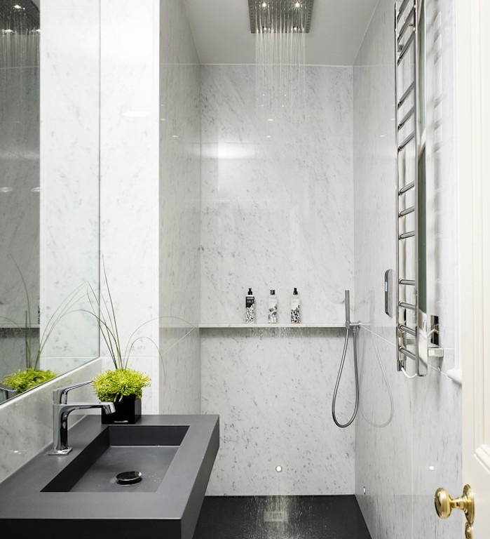 réalisation salle de bain italienne petite surface avec carrelage sol noir et lavabo noir, murs marbre et douche pluie