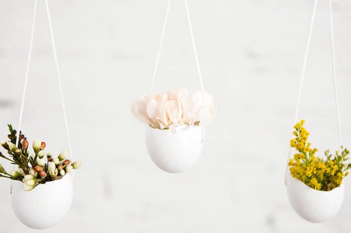 pot de fleurs en coquille d oeuf suspendu à un fil blanc avec de petits bouquets à l intérieur, deco paques originale