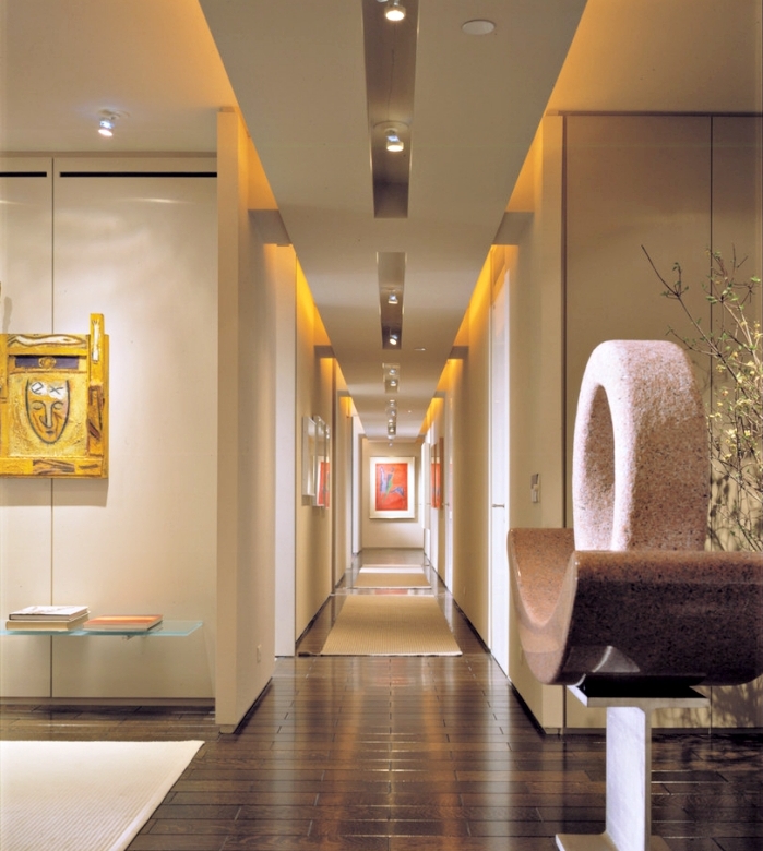 modèle de deco entree aux couleurs et finitions moderne avec parquet de bois foncé et objets décoratifs en or