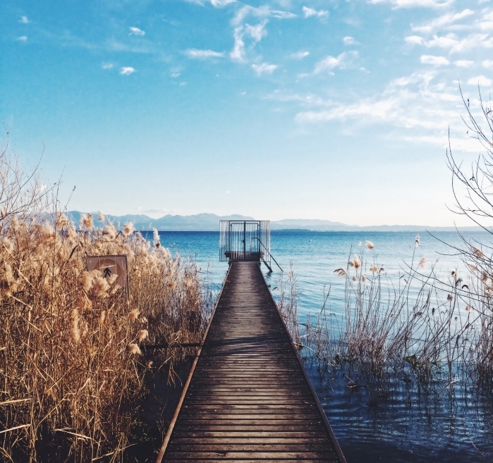 photo avec fond d écran beau, pont de bois au-dessus d'un lac turquoise qui donne une vue vers les montagnes