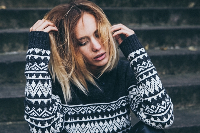 modèle de pull femme en noir avec motifs géométriques en blanc, ombré blond aux reflets cuivrés sur cheveux marron