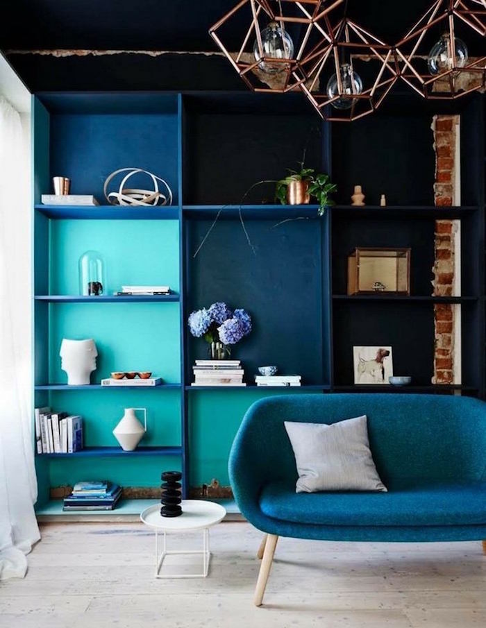 salon de loft tendance bleu pétrole, appartement style industriel rétro avec lustre design et canapé paon