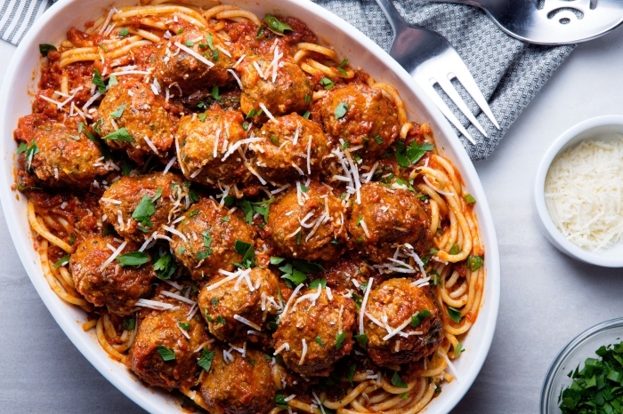 idée repas entre amis de la cuisine italienne, recette de spaghettis à la sauce tomate et boules de viande hachée avec herbes fraîches