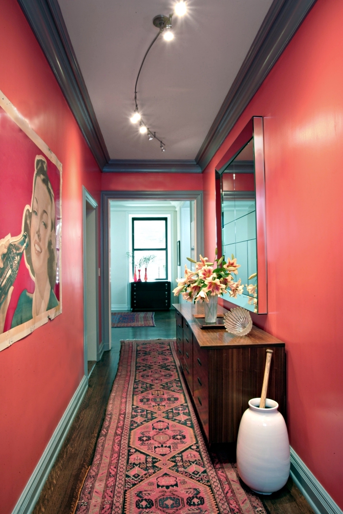modèle de deco hall entrée aux murs rouge avec plafond blanc en bordure foncé et plancher de bois marron