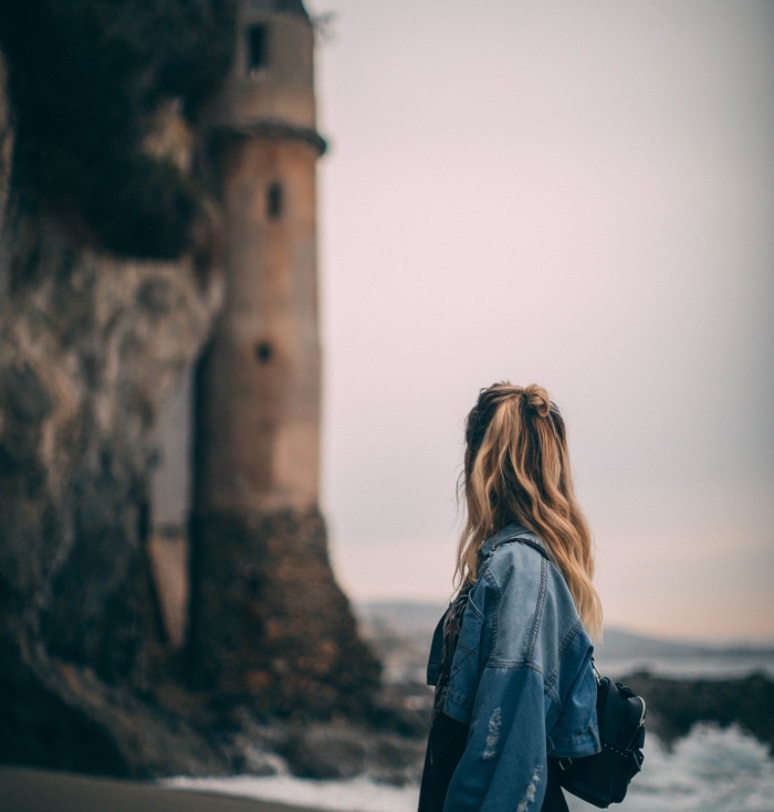 coiffure romantique de style naturel aux cheveux mi-attachés en demi bun, combiner le sac à dos cuir noir avec veste en denim