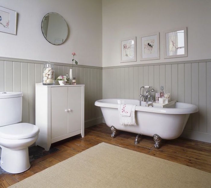 salle de bain gris clair rétro avec bas de mur en bois et tapis de bain beige