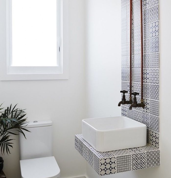 petite salle de bain design avec vasque blanc et carrelage bande noir et blanc, wc et murs blancs