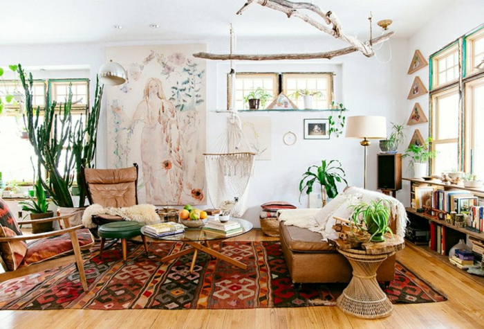 tapis boheme, chaise en bois et textile, petits tabourets, chaise en cuir, penture murale blanche, sol en bois, grands cactus