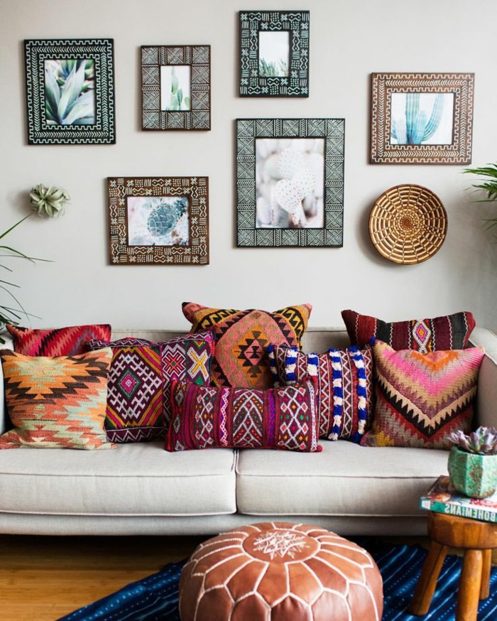 sofa en couleurs claires, coussins ethniques en couleurs intenses, tableaux encadrés, pouf marocain