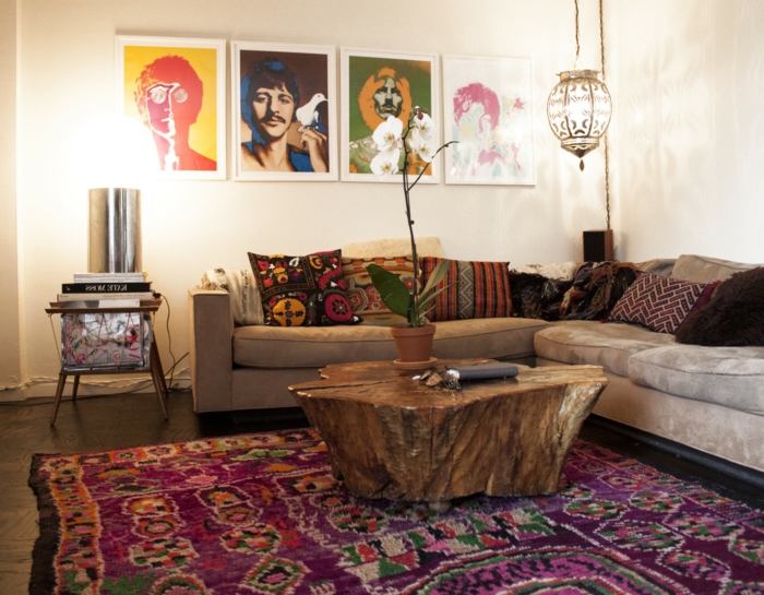 peintures pop art en cadres bmancs, tapis pourpre aux motifs ethniques, sofa beige taupe