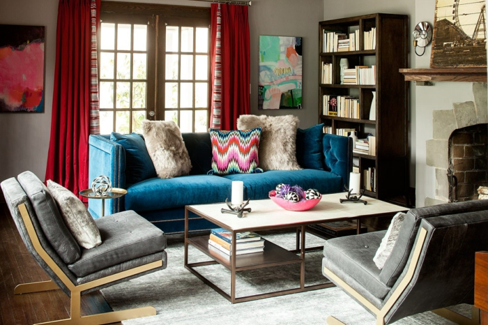 salon style boheme, sofa bleu, table en bois et fer, cheminée, bibliothèque en bois