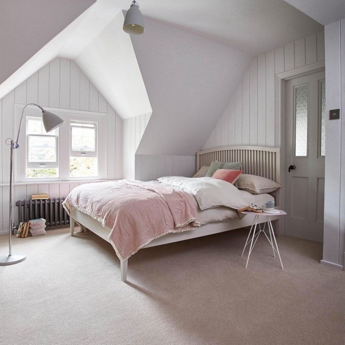 idée déco chambre à coucher sous pente aux murs blancs, déco simpliste avec grand lit à tête de bois et lampe sur pied