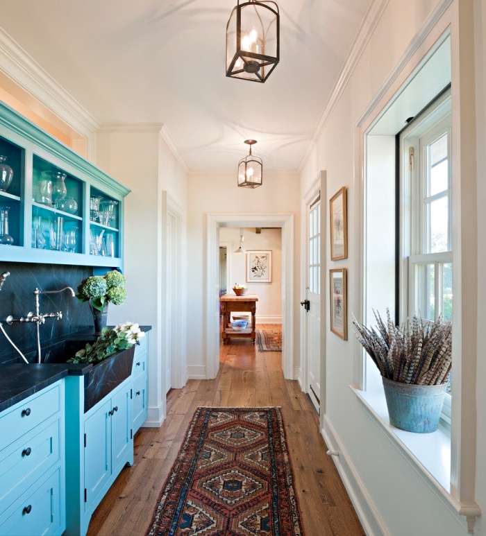 style campagne et rétro dans un couloir et cuisine ouverte avec équipement de nuance bleu et murs peints en blanc