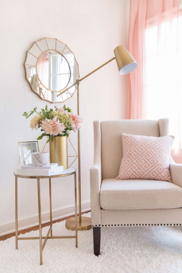 aménagement coin de lecture avec fauteuil beige et coussin rose et blanc, modèle de table en verre et cuivre