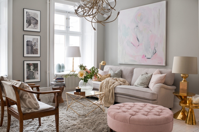 deco salon gris avec canapé de couleur rose pale et fauteuil de bois marron foncé, modèle de tables rondes et lampe à design cuivré