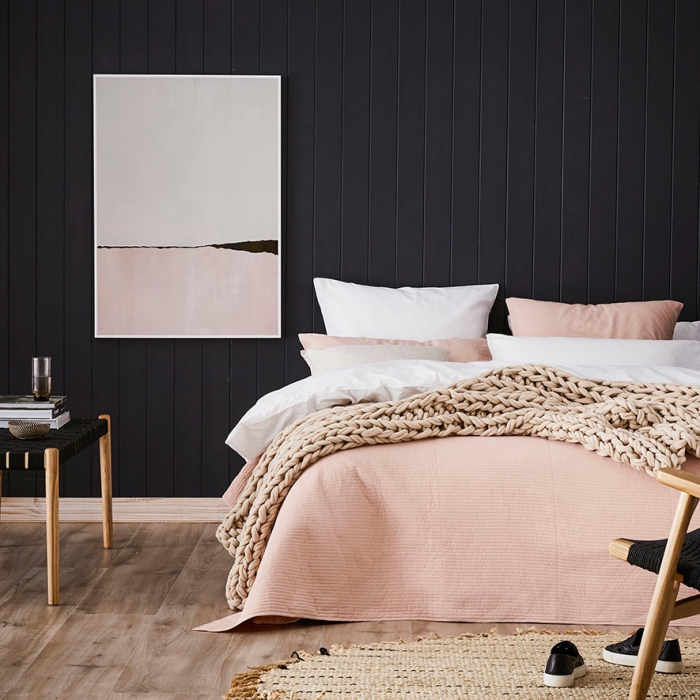 déco de chambre à coucher aux murs foncé et parquet de bois avec linge de lit rose poudré et tapis beige avec frange