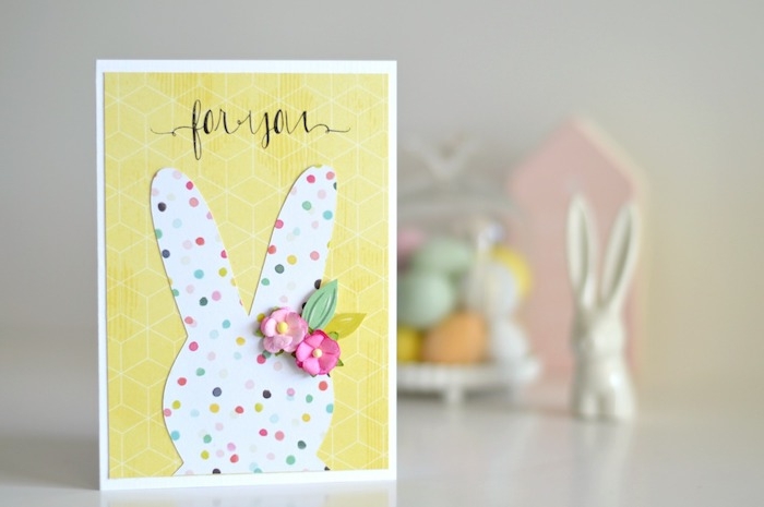 carte de paques a faire soi meme avec silhouette de lapin de paques blanc à pois colorés et fleurs artificielles sur fond jaune