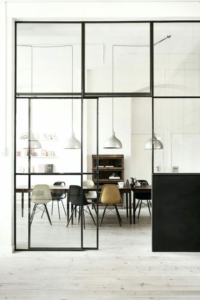 decoupe verre en métal noir, avec des grands carrés en verre, salle a manger avec grande table rectangulaire et des chaises en plastique marron et noir