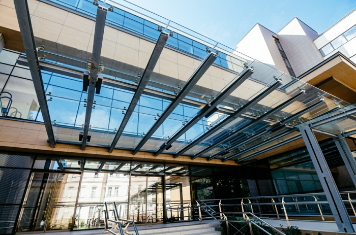 verrière au-dessus d'un édifice administratif, éléments massifs en verre, entrée principale avec des profils en aluminium noirs et du verre