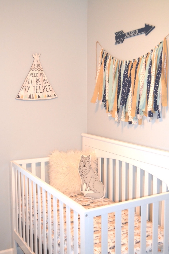 objets décoratifs pour les murs à design ethniques, idée déco au-dessus d'un lit bébé en bois blanc couvert avec coussins