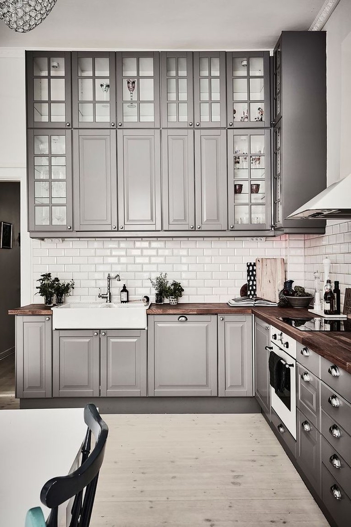 une cuisine conviviale et chic aux placards hauts jusqu'au plafond avec des portes vitrées, couleur pour une cuisine gris taupe tendance
