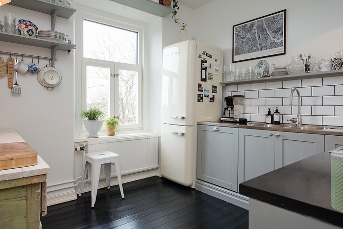 les meubles de hauts sont remplacés par une étagère murale ouverte qui donne un aspect rustique à cette cuisine blanche et grise