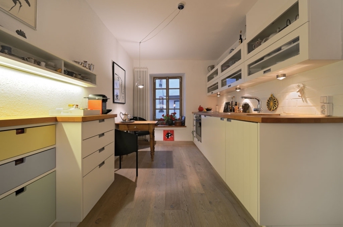 quel éclairage choisir pour aménager une cuisine en longueur aux murs blancs et plancher de bois stratifié foncé