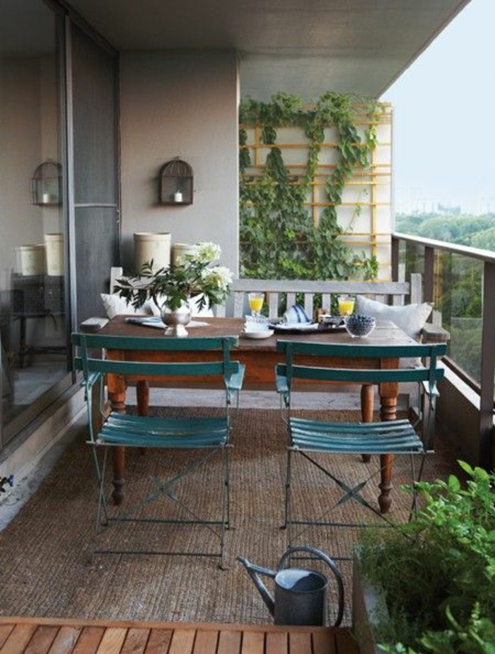 chaises pliables en bois et métal en vert canard, idee amenagement terrasse, vieille table d'intérieur en bois marron, mur végétal en bois clair avec des plantes rampantes 