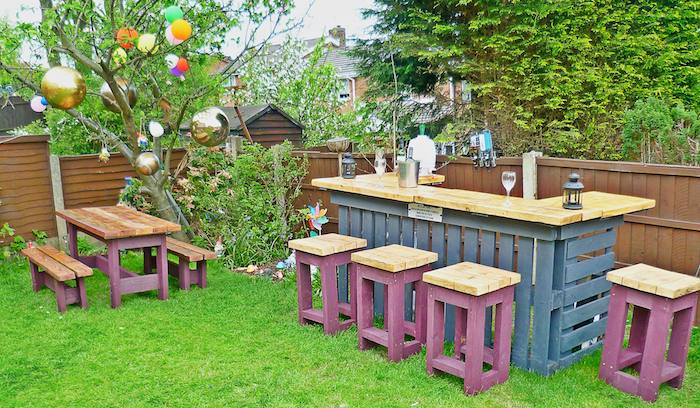 comment faire un bar en palette de bois avec bancs, table basse et tabourets mauve sur gazon dans un jardin