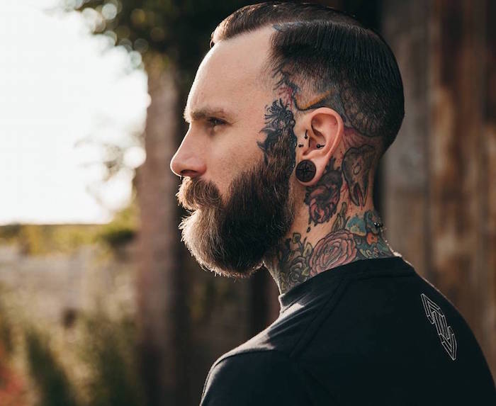 style de barbe en dégradé à partir des oreilles accordée avec une coupe pompadour courte et fondu américain pour hipster avec tatouages dans le cou