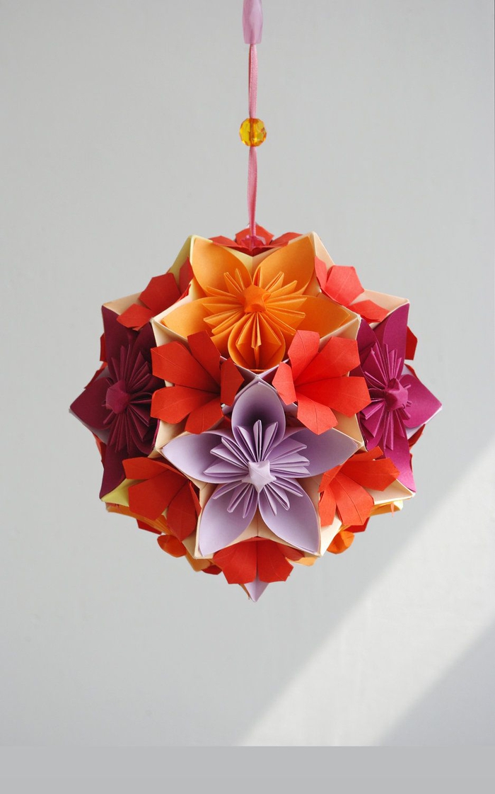 une boule kusudama multicolore composées de fleurs en origami collées ensemble, modele origami d'une fleur traditionnelle pour l'art de pliage origami japonais