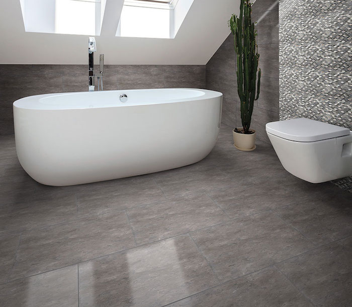 salle de bain mansardée avec baignoire ilot blanche ovale et carrelage gris marbré brillant