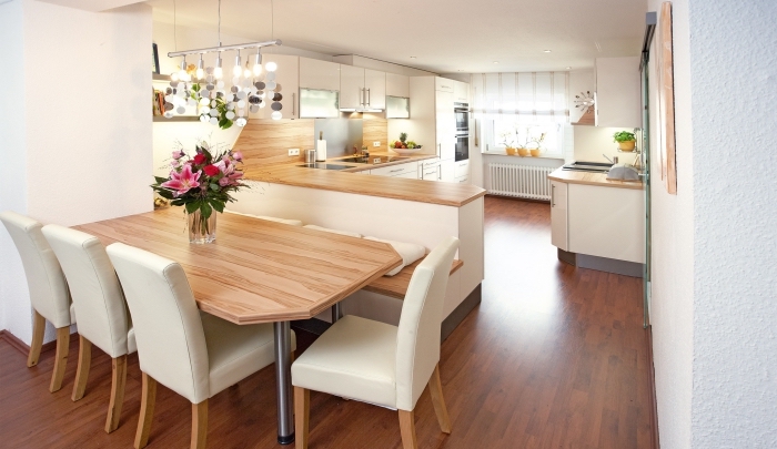 design moderne dans une cuisine ouverte vers la salle à manger bien équipée avec plancher de bois marron et plafond blanc