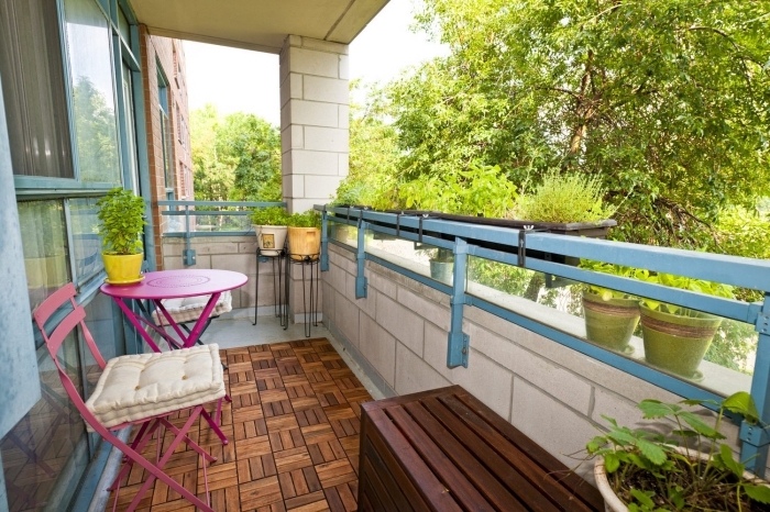 jolie décoration de terrasse ou balcon avec carrelage de sol à imitation bois et meubles table et chaise en rose