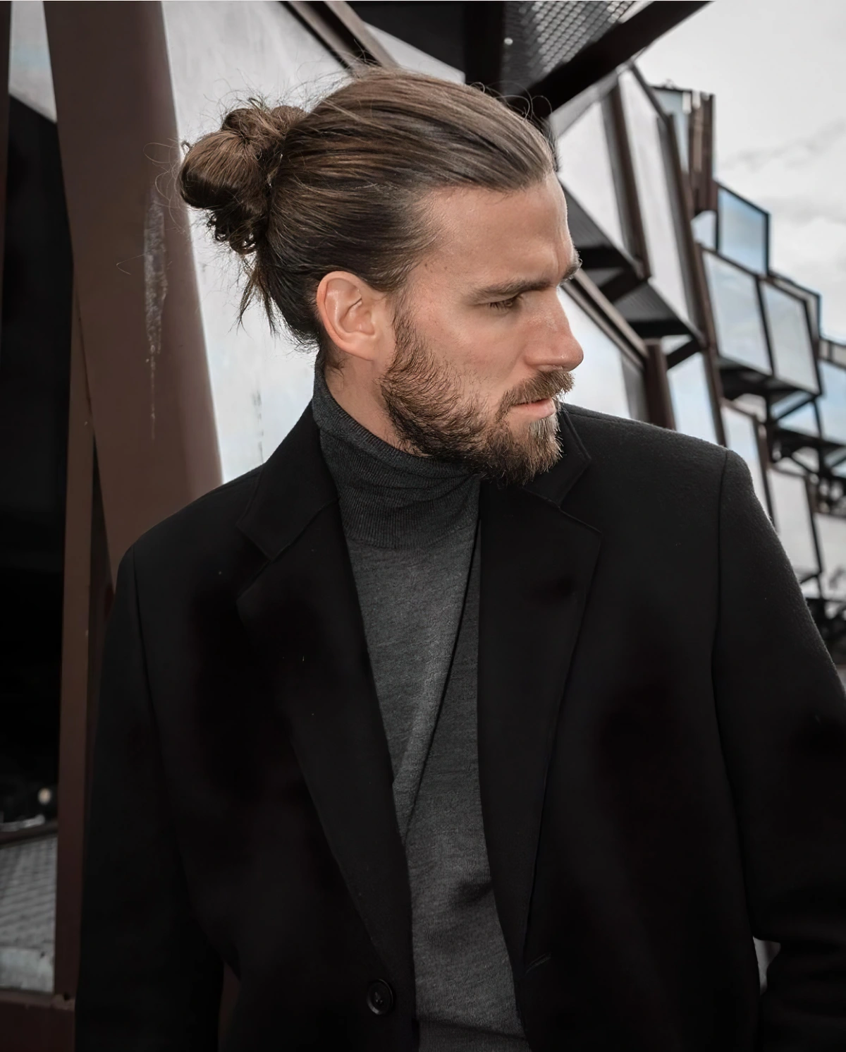 cheveux en chignon haut messy homme blazer noir pull gris