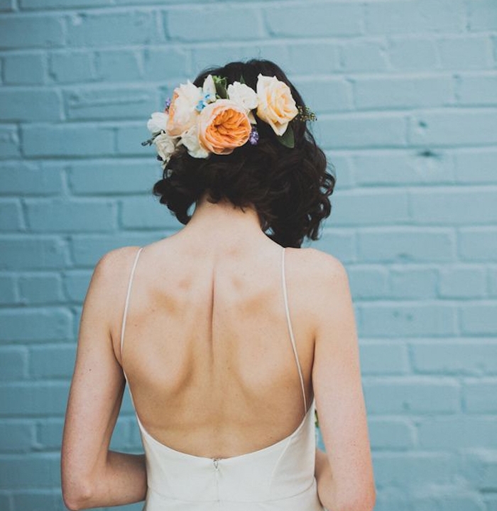 robe de mariée dos nu avec carré plongeant bouclé accessoirisé de fleurs, coiffure cheveux carré boheme