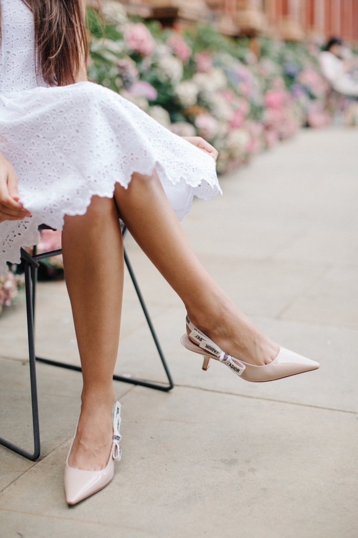 look romantique avec robe mi-longue blanche à design dentelle combinée avec une paire de chaussure à bride arrière de couleur nude