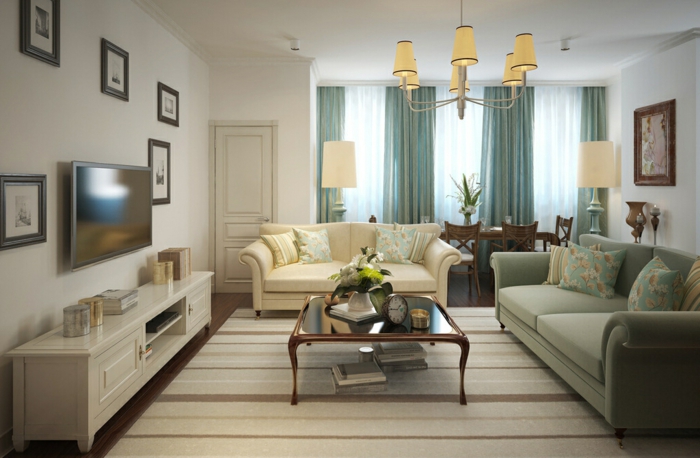 tapis rayé, table basse en bois et verre, meuble de tv blanc, sofa couleur crème, rideaux bleus