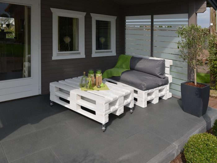 deco terrasse couverte sous pergola moderne avec fauteuil en palette blanchi et table palette basse en blanc à roulettes