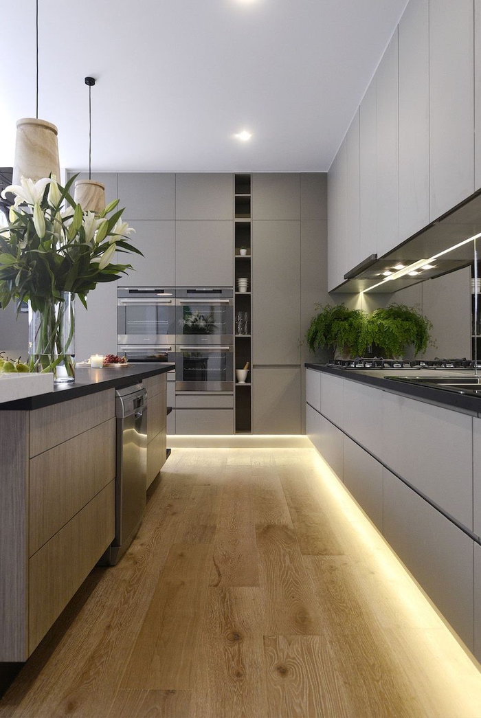 conception moderne d'une cuisine gris clair mat aux lignes épurées avec ses meubles sans poignées jusqu'au plafond
