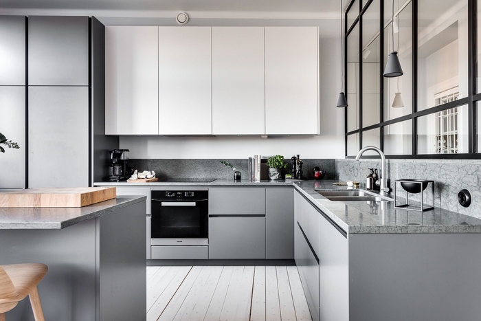 une cuisine blanche et grise au design épuré minimaliste qui associe simplicité et élégance grâce à quelques accents noirs