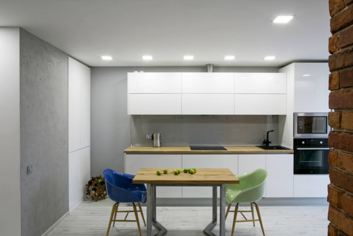  quelle couleur pour les murs d'une cuisine blanc laqué, design minimaliste et épurée d'une cuisine blanche laquée rehaussé par les murs gris et le comptoir en bois clair