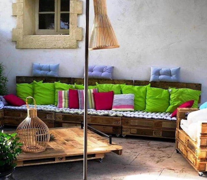 decoration jardin avec canapé long en palettes et table à roulettes palette, deco style méditerranéen, maison ancienne